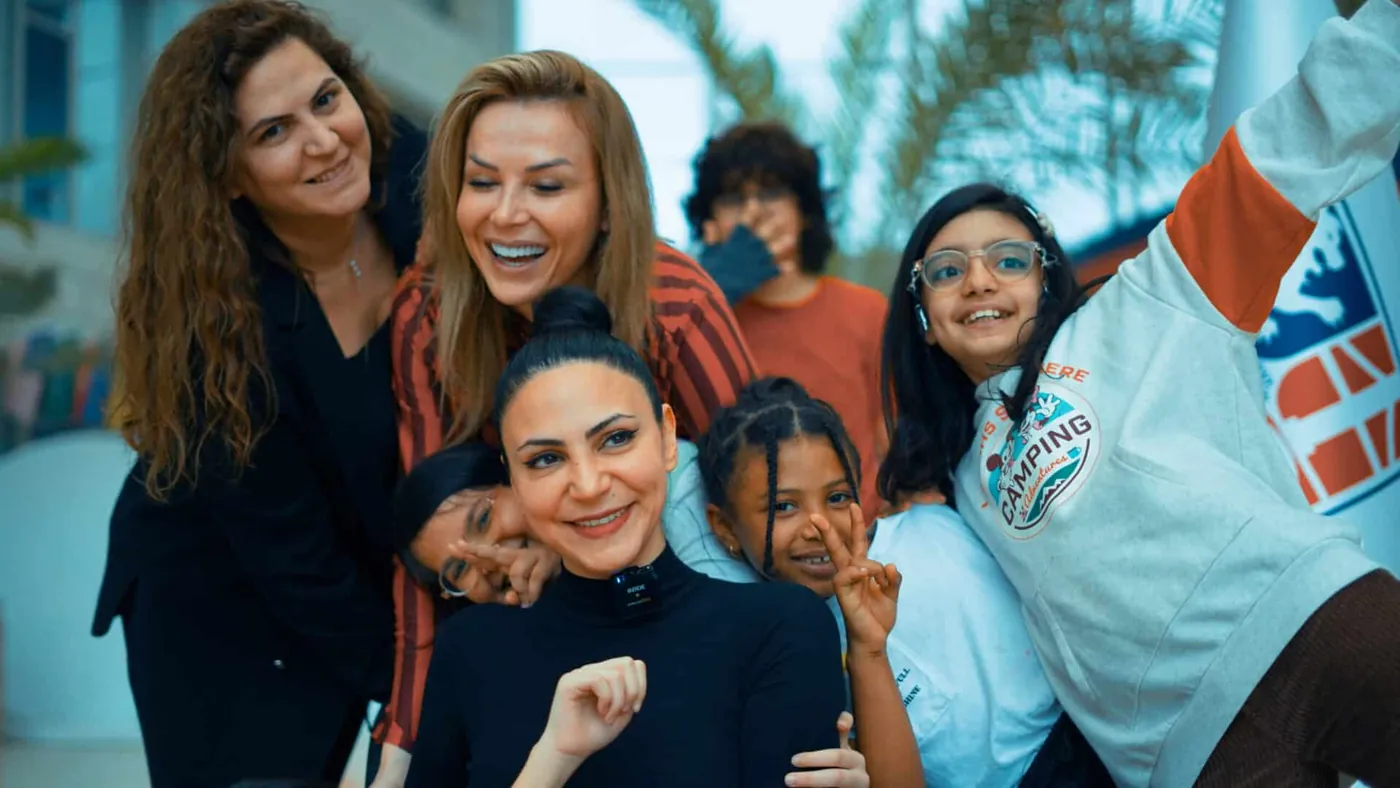 Teachers and students smiling together at Gökkuşağı Schools